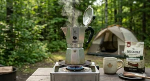 A portable Bialetti Moka pot heating over a campfire at a Canadian provincial park, perfect for rugged outdoor brewing.